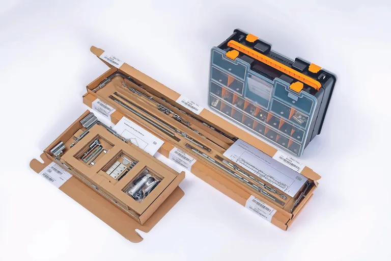 Das Nachrüstset von Winkhaus besteht aus einem Nachrüstkoffer sowie drei Kartons. Der Grundkarton enthält Lager, der höhenabhängige Karton Getriebe und Verlängerungsbauteile und der breitenabhängige Karton Oberschiene und Schere.