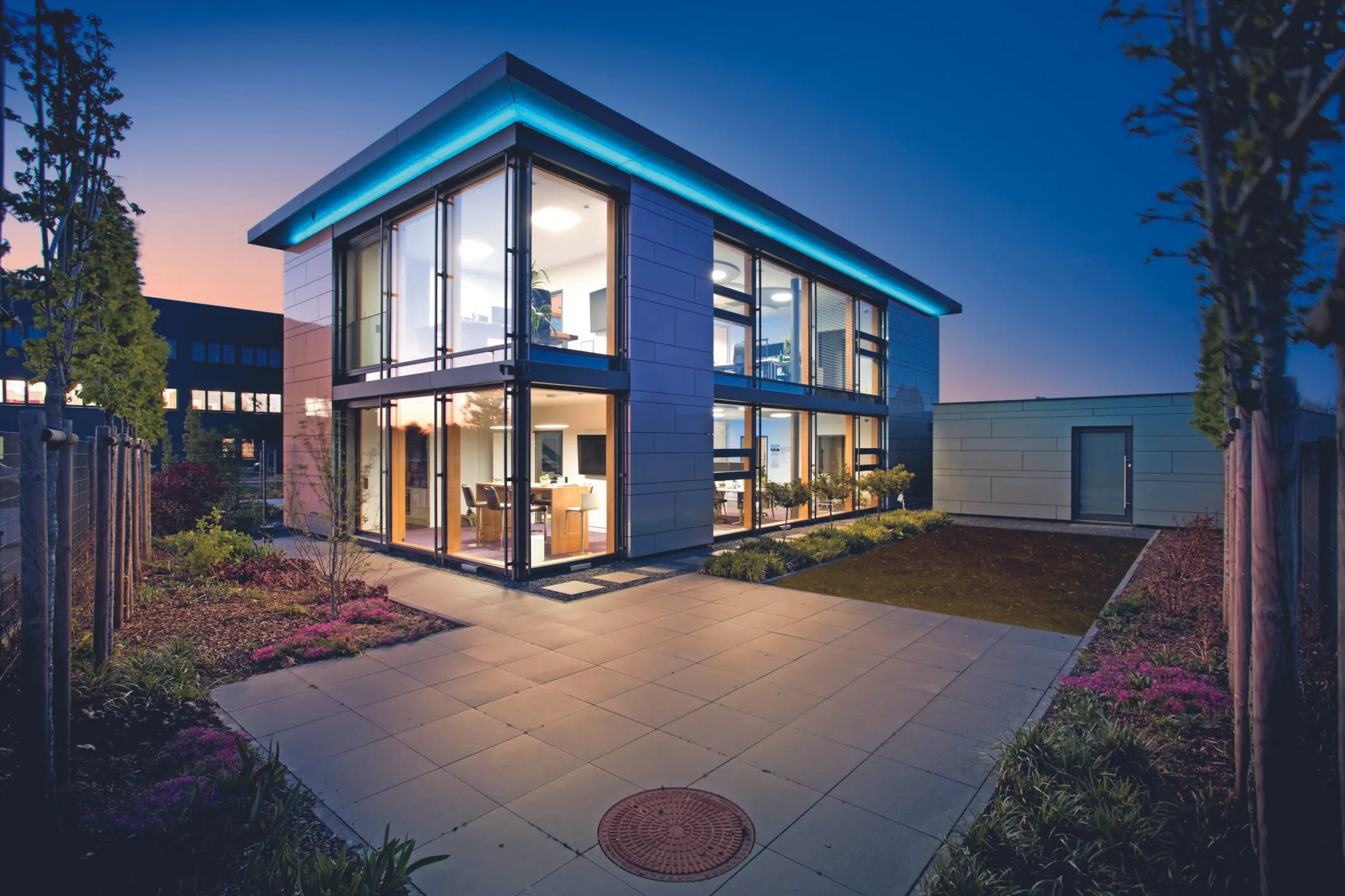 Die bodentiefen Fenster und Glasflächen über zwei Stockwerke hinweg lassen den Büroneubau transparent erscheinen.