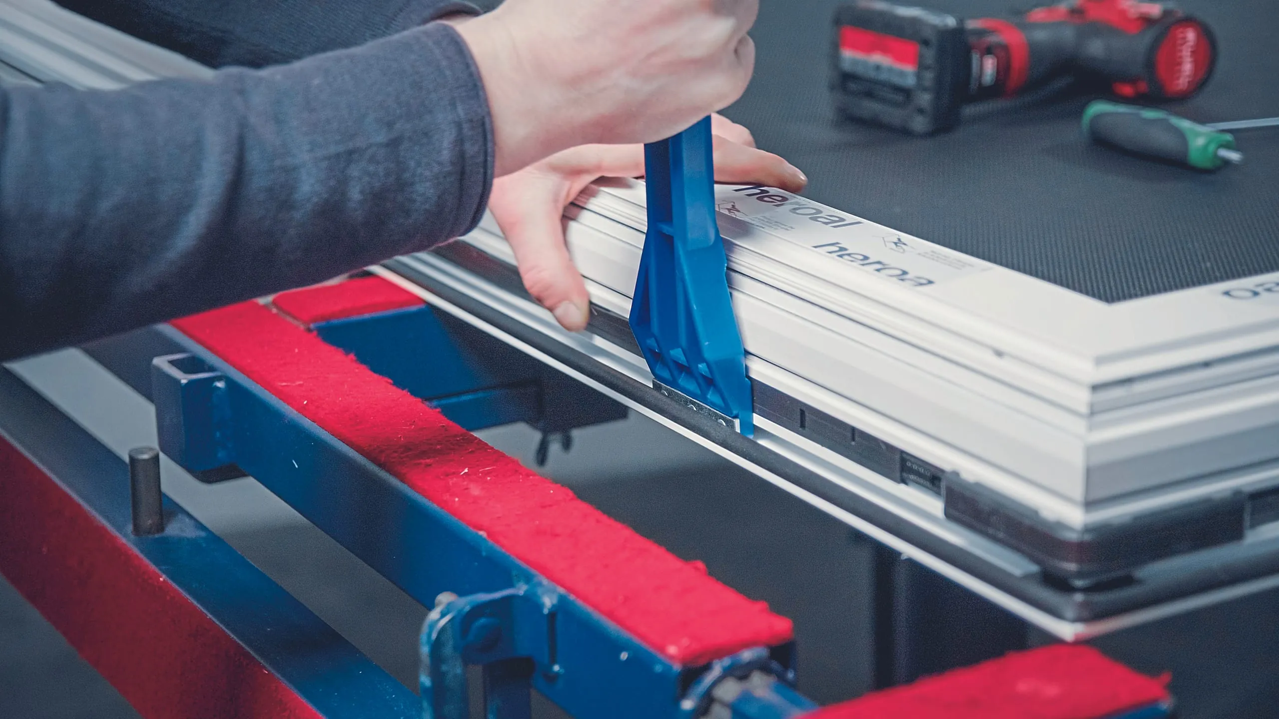 3. Schritt: Mit Treibstangen verbinden Sie das Getriebe mit den Eckumlenkungen. Legen Sie die Treibstangen hierzu in die Beschlagsnut ein und drücken Sie sie mit dem Montagehebel ein. Schwenken Sie das Flügellager an der unteren Bandseite in die Beschlagsnut ein und fixieren Sie es mit einem Klick.