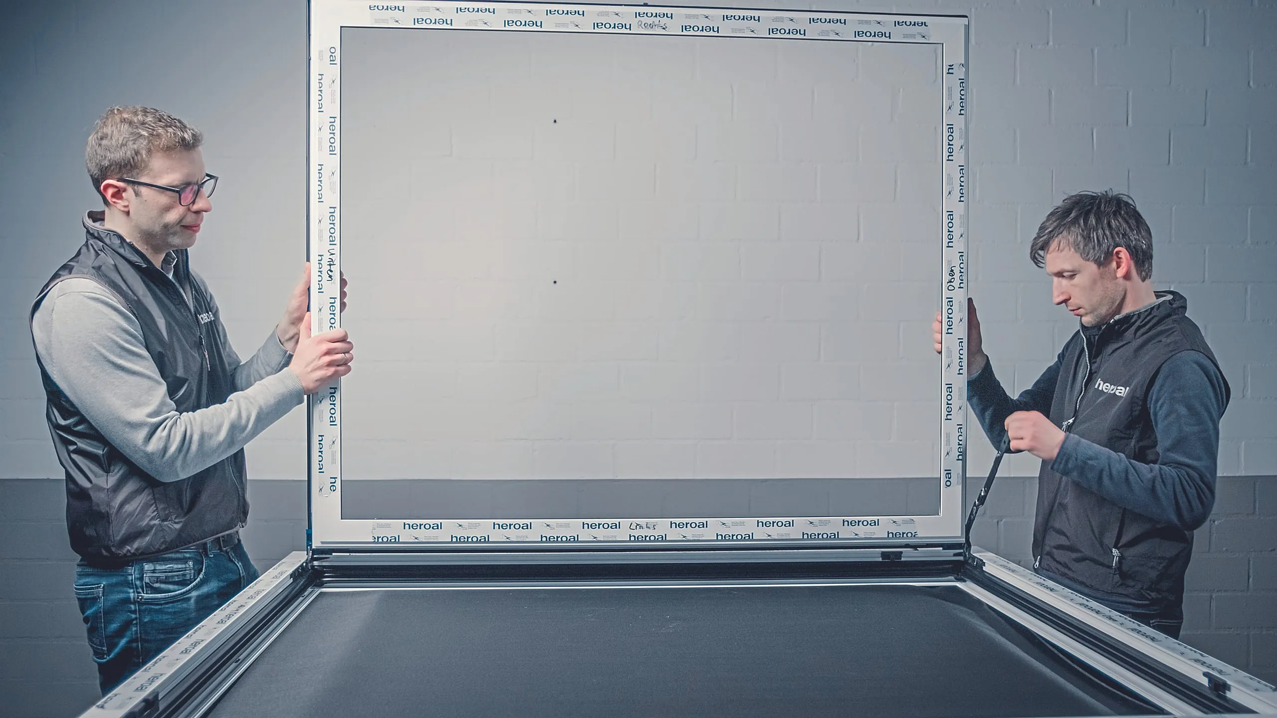 7. Schritt: Montieren Sie den Flügel am Rahmen. Dazu schieben Sie den Kantenschutz auf die Flügelecken, schieben die Lager ineinander und verbinden beide fest mit einer Drehung. Verbinden Sie die Schere mit der Oberschiene und verdrehen Sie die Sicherungsfeder.