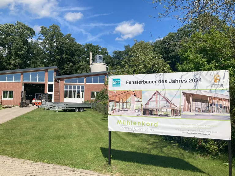 Direkt am Firmengel&auml;nde in Verl stellte M&uuml;hlenkord ein Plakat auf, das Radfahrer und Passanten auf die Auszeichnung des Betriebs hinweist.