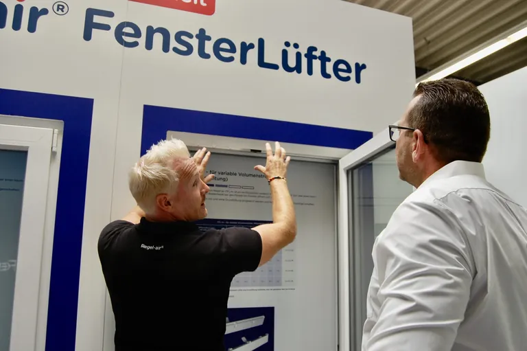 Thomas Verhoeven (l.), Geschäftsführer bei Regel-air, erklärt Denis Fellner im Showroom am niederrheinischen Firmensitz die unterschiedlichen Funktionsweisen der verschiedenen Fensterfalzlüfter.