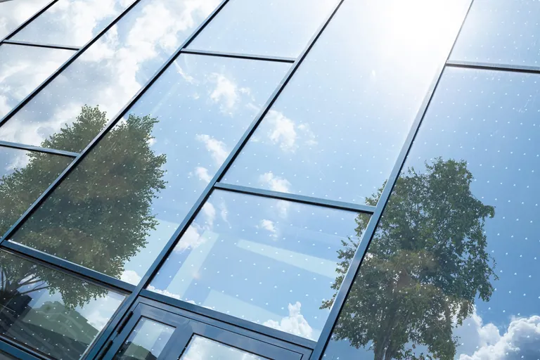 Die PVB-Folie Saflex FlySafe 3D schützt mit reflektierenden Pailletten vor Vogelschlag. Die Optik der Verglasung bleibt dabei nahezu unbeeinträchtigt.