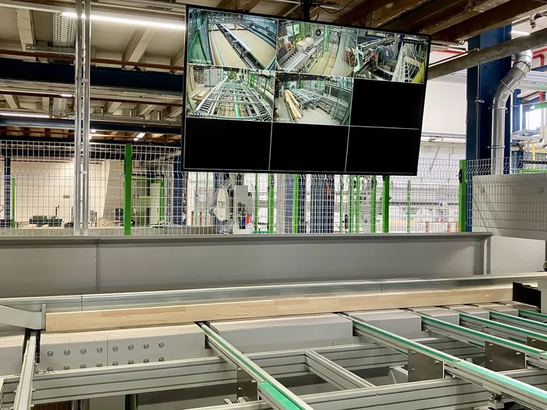 Das Auflegen: Die Rasterma&szlig;e und sechs Meter langen keilgezinkten Fensterkanteln werden zur Pr&uuml;fung vermessen und dann verschnittoptimiert gekappt. Der Bildschirm zeigt lediglich f&uuml;nf der insgesamt 23 zur permanenten Qualit&auml;tskontrolle in der Anlage verbauten Kameras.