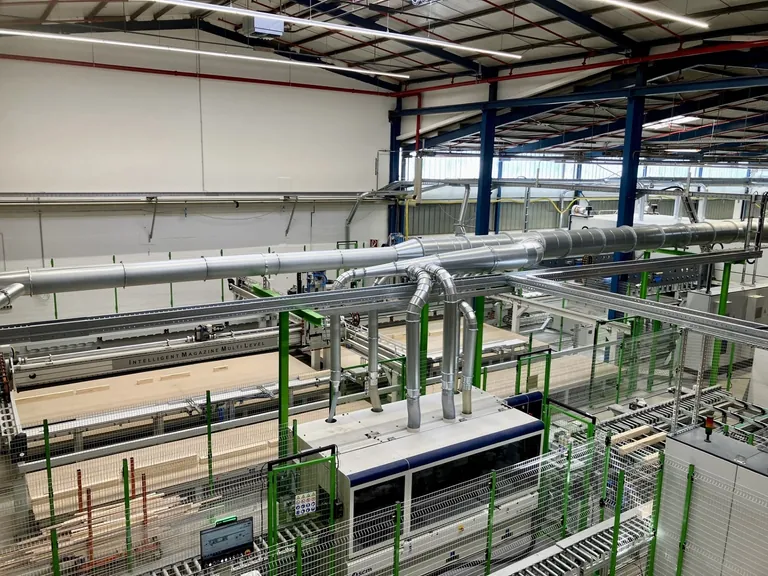 Unten zu sehen ist der SCM Hobelautomat mit sieben Spindeln, wo die Kanteln ausgehobelt und die Glasleistenrohlinge ausgetrennt werden. Auf der anderen Seite befinden sich die erw&auml;hnten Pufferr&auml;ume: Die Intelligent Magazine Multi-Level (IMML) werden zur Vermeidung von Leerlaufzeiten wechselseitig best&uuml;ckt.