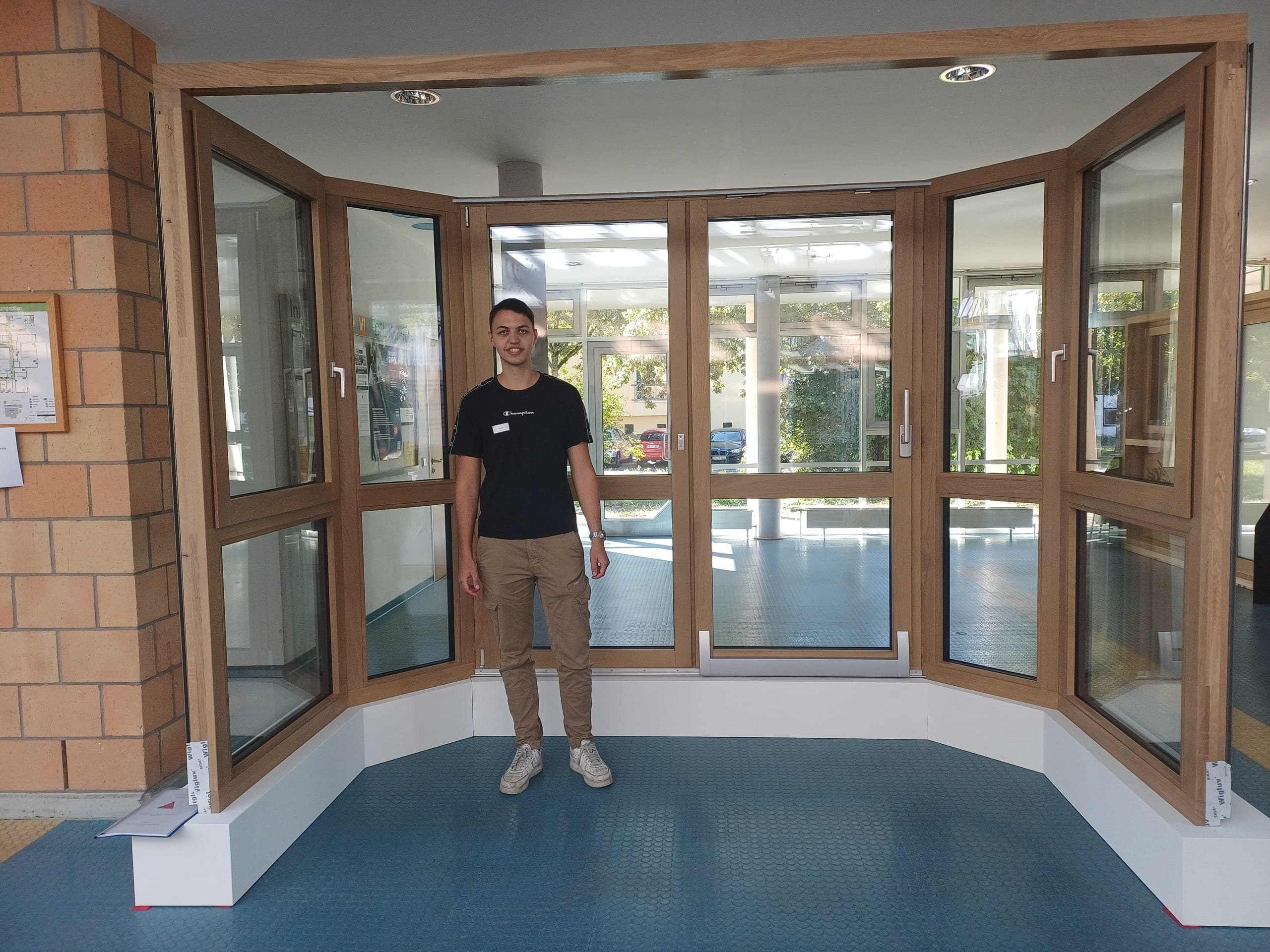 Till Klopfer von Fensterbau Klopfer baute eine Parallel-Schiebe-Kipp-Tür (PSK-Tür) mit 45-Grad-Eckkombinationen, alles aus Holz-Aluminium. Die PSK-Tür besitzt statt einem feststehenden Seitenflügel eine Drehflügeltür mit eingelassener Rosette. An dieser kann der bewegliche Flügel problemlos parallel vorbei geschoben werden. Die äußersten Seitenteile sind mit Dreh-Kipp-Fenstern und verdeckten Beschlägen ausgestattet. Das Meisterstück hat Klopfer als Ausstellungsstück für seinen Familienbetrieb konzipiert, damit Kunden im Showroom unterschiedliche Lösungen (sichtbare vs. verdeckte Beschläge, Schieben & Kippen) in einem einzigen Element begutachten können.