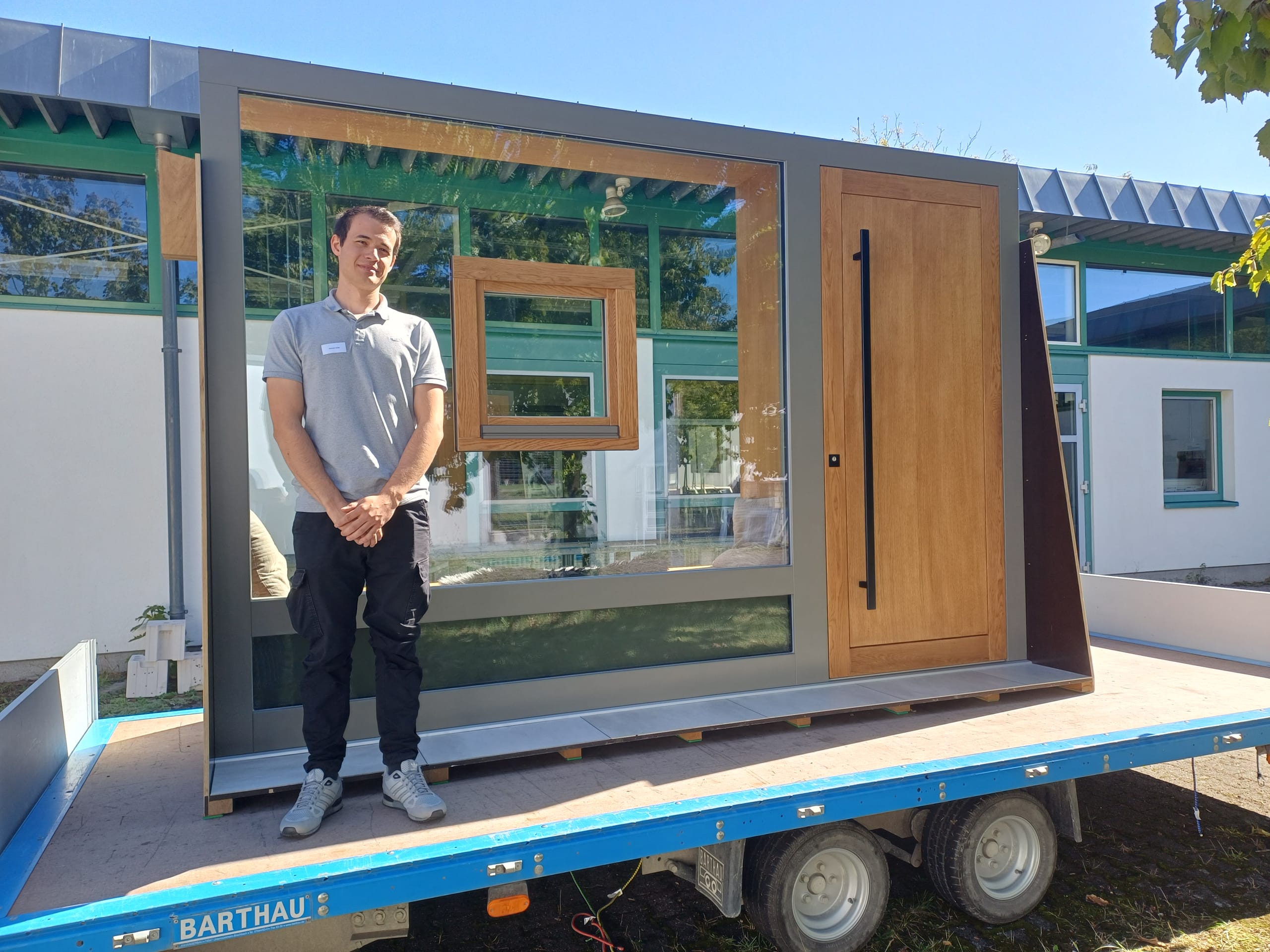 Beim Meisterstück von Hendryk Urban von Fensterbau Nill handelt es sich um eine Eingangstür mit einer Festverglasung als Seitenteil, in die mittig ein "freischwebendes" Fenster integriert ist. Das Holzfenster aus Eiche hat der Meisterschüler in einen Lochausschnitt in der Festverglasung aus ESG eingelassen. Auch die Haustür besteht aus Eiche, während der Blendrahmen für einen farblichen Kontrast aus Quarzgrau lackierter Fichte besteht. Auf der Innenseite hat Urban einen Schuhschrank eingebaut, der auch als Sitzfläche dient und von dem aus man direkt ins Freie blicken kann.