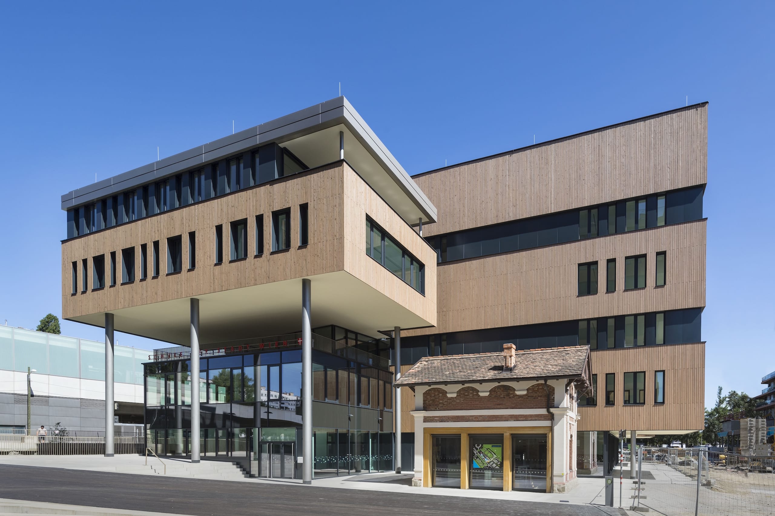 Da die Grundstücksfläche der Olly-Schwarz-Schule ungewohnt klein ist, erforderte dies eine höhere Bebauung von 22 Meter, die sich im Massstab dem benachbarten Wohnkomplex nähert. Fünf Geschosse plus Dachgeschoss und zwei Untergeschosse umfasst die Ganztagesvolksschule, die damit Raum für 17 clusterbasierte Klassen und rund 400 Schülerinnen und Schüler bietet. In unmittelbarer Nähe zum Schulgrundstück befindet sich zudem das "Zuckerlhaus“, ein denkmalgeschützter Kopfbau der ehemaligen Stallungen, der erhalten bleiben musste.