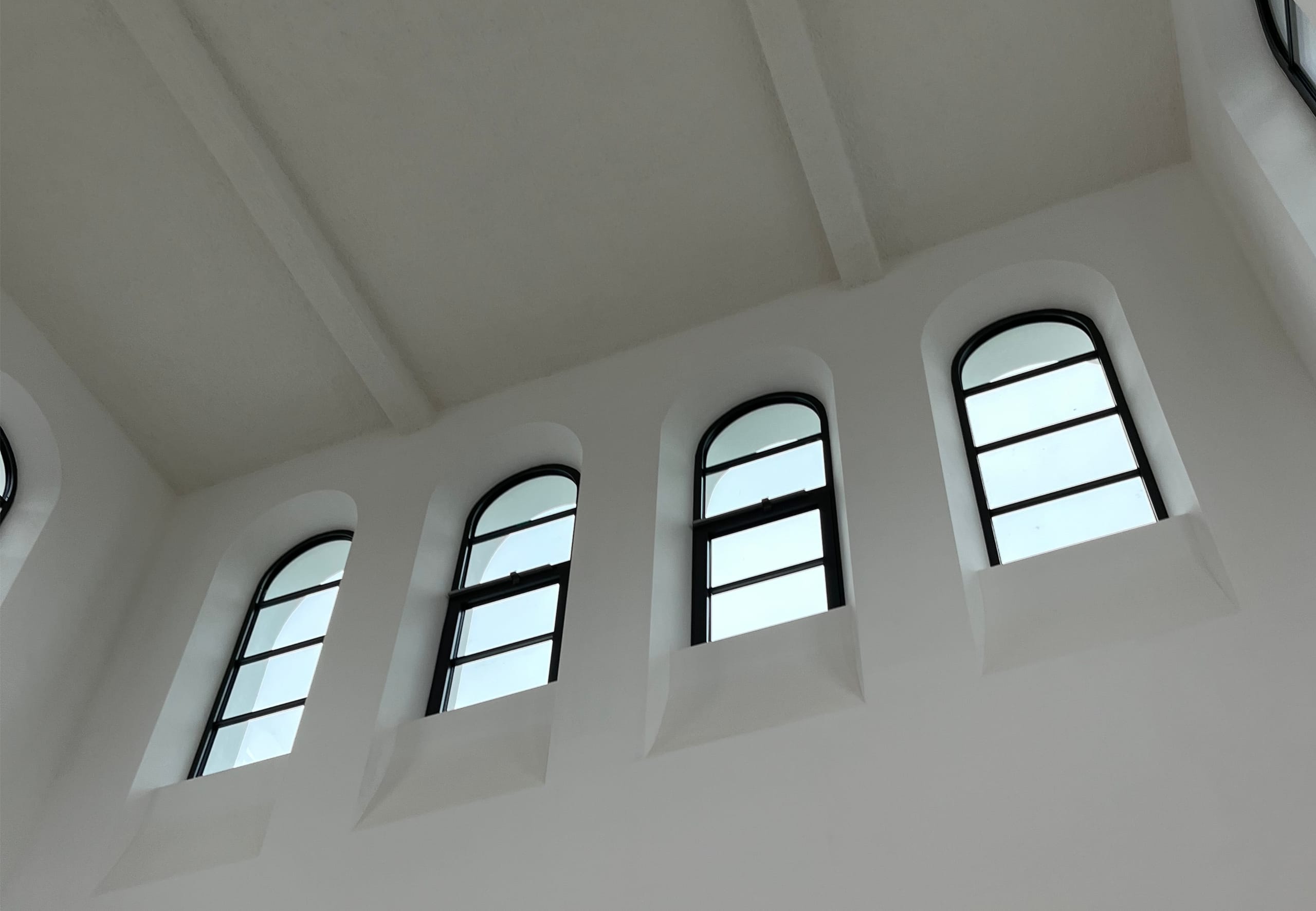 Ein besonderes architektonisches Merkmal sind die geschwungenen Fensterformen, die sorgfältig restauriert und in die moderne Fassadengestaltung integriert wurden. Sie verleihen dem Gebäude nicht nur seinen einzigartigen Charakter, sondern sorgen auch für viel Tageslicht und eine freundliche Lernatmosphäre.