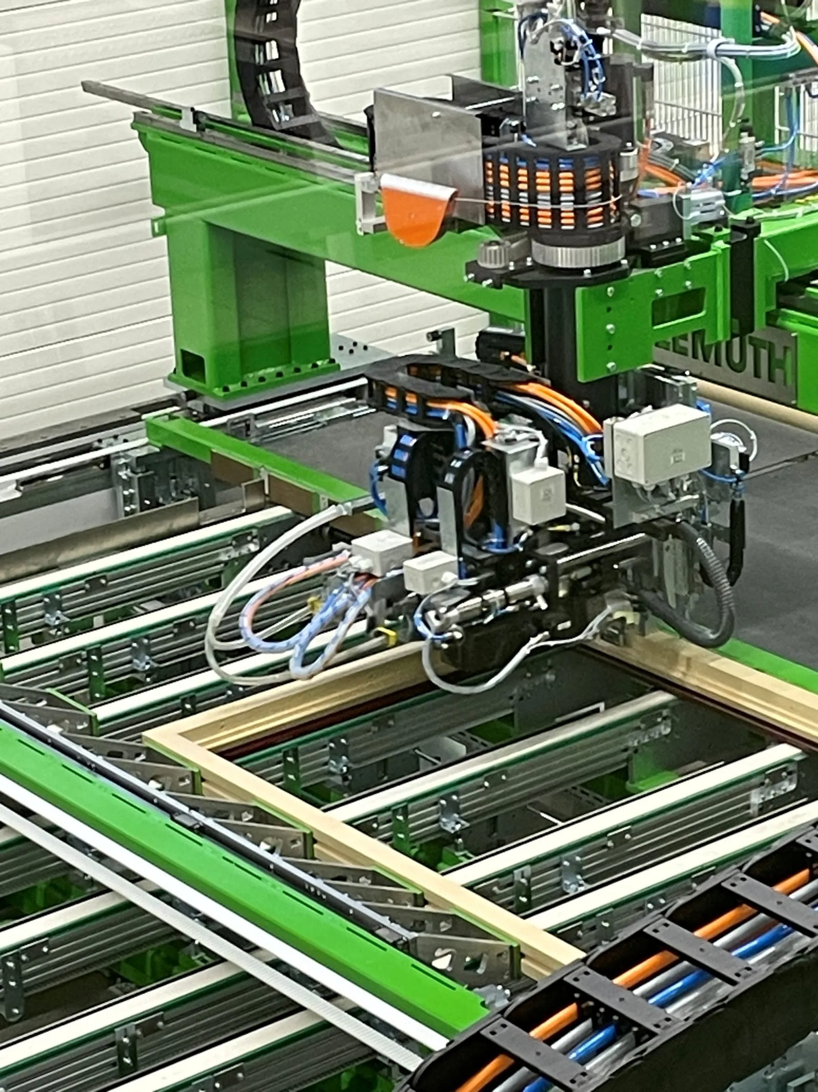 Der Beschlagautomat ist das Herzstück der Endmontage, er führt die Beschlagteile selbstständig zu, bohrt und verschraubt sie hochpräzise am fertigen Rahmen.