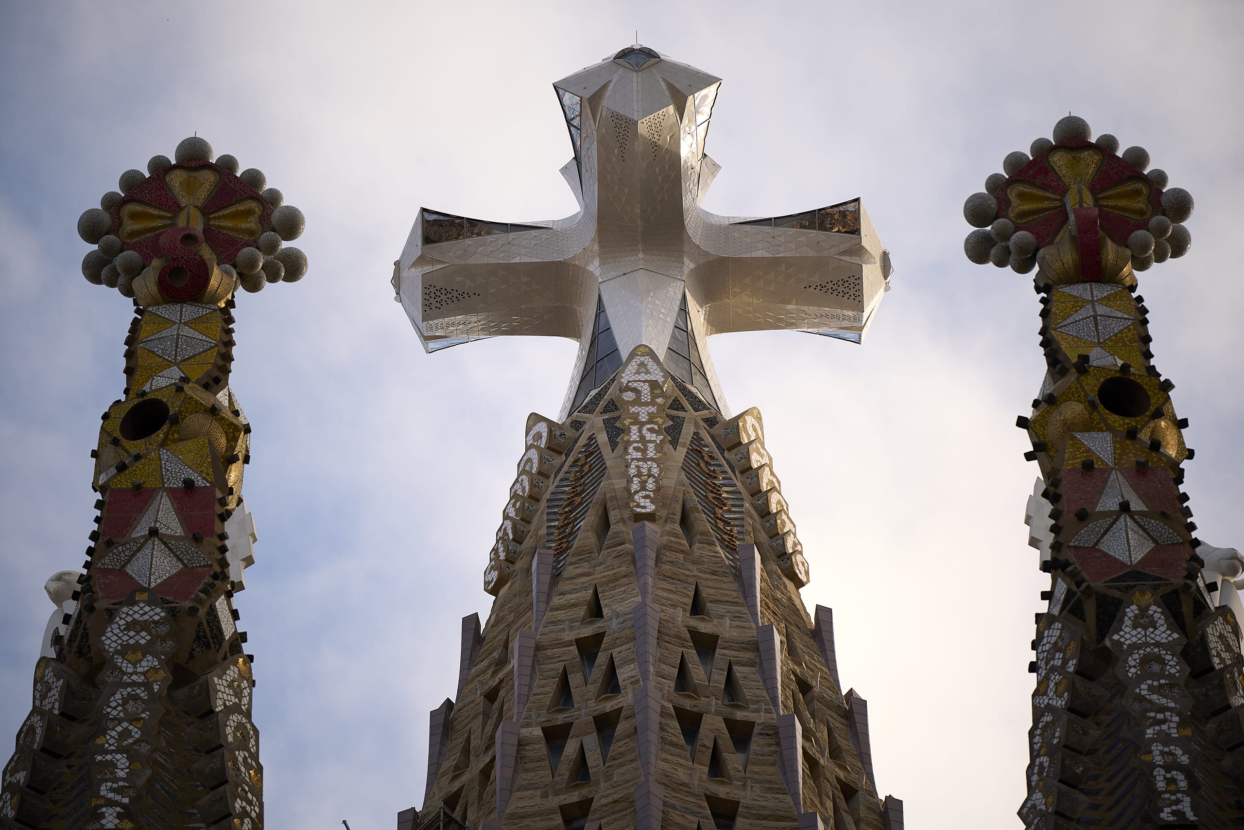 Die Planungen für das Glaskreuz gehen auf eine Handzeichnung von Antoni Gaudi zurück. Wie die Säulen und Kreuze der Sagrada Familia folgt auch das Glaskreuz einer Doppeldreh-Geometrie und erforderte eine verdrillte Konstruktion. Die achteckigen Arme und die Spitze des Kreuzes verdrehen sich dabei zu einem quadratischen Endstück.